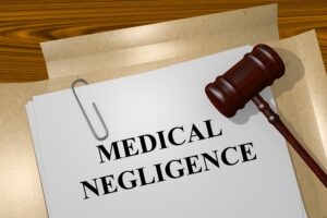 'Medical Negligence' written on a piece of paper on a document folder with a gavel on it.