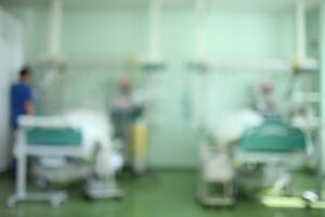 A blurred image shows a hospital critical care ward. 